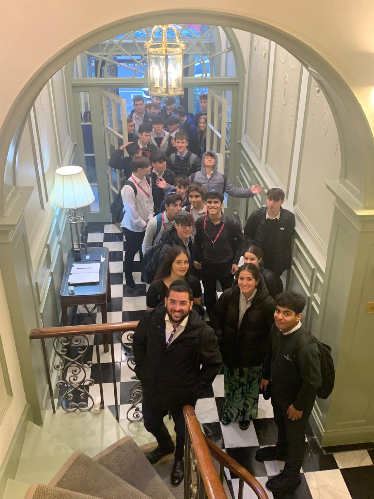 Rabbi Aidyn with students on a grand staircase
