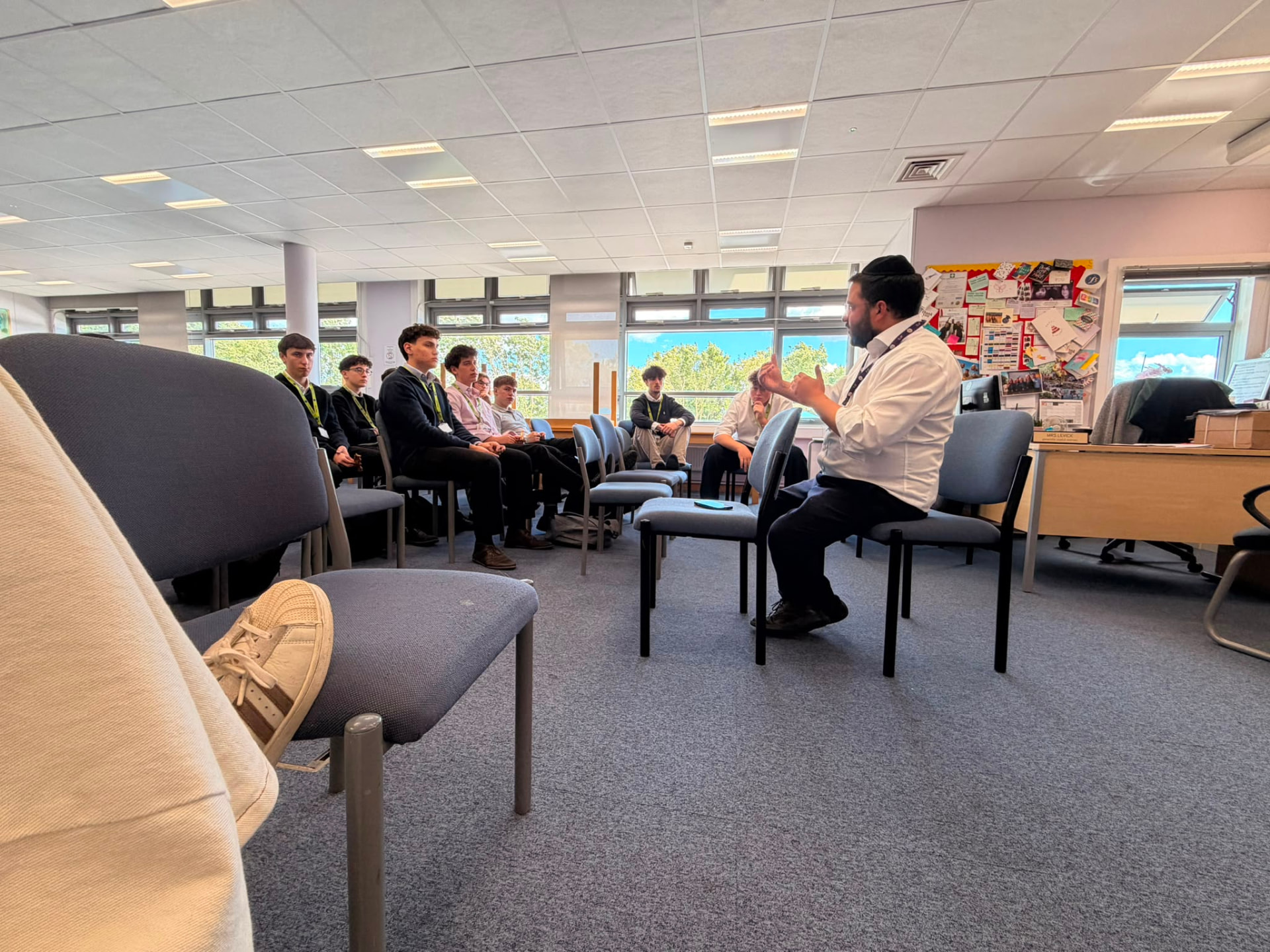 Rabbi Aidyn speaking with students seated in a circle