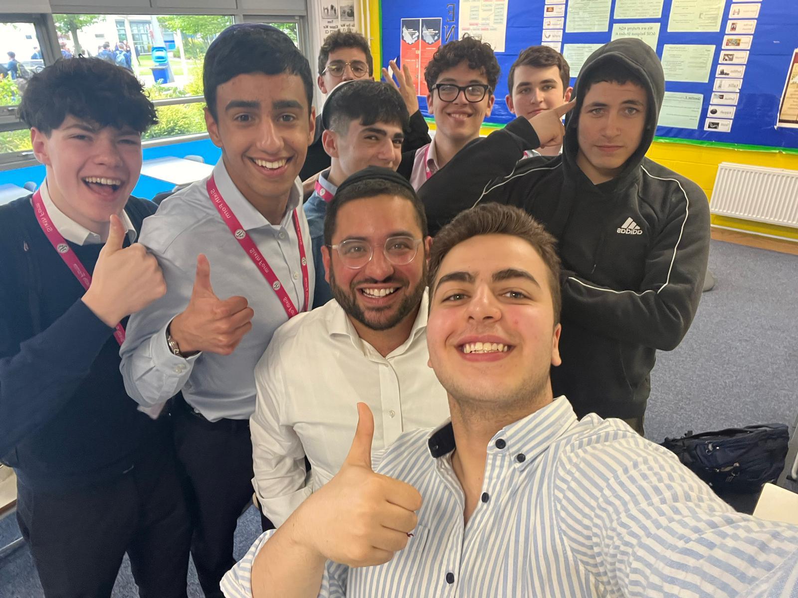Rabbi Aidyn with a group of students giving thumbs up