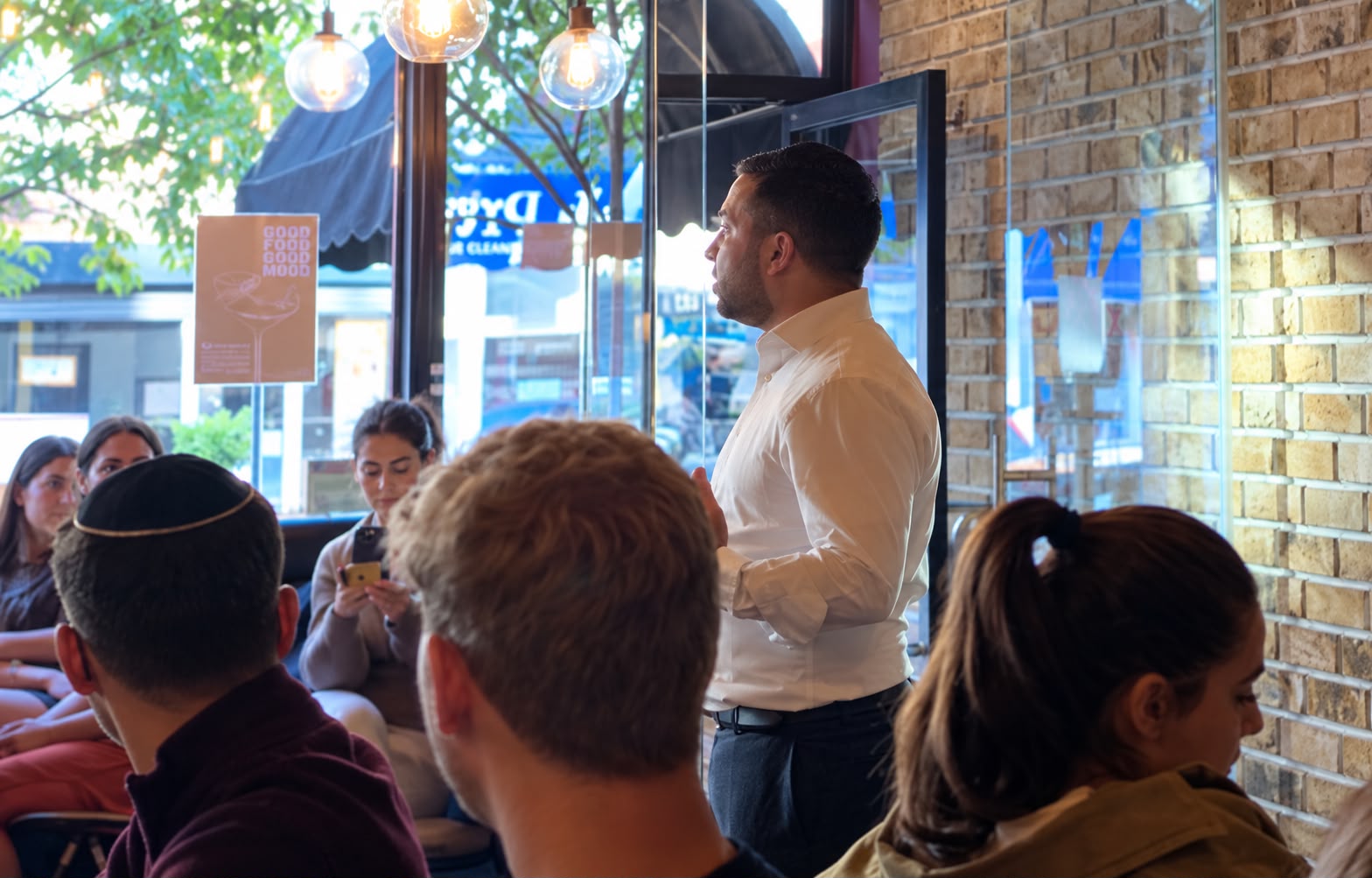 Rabbi Aidyn talking with young people in a cafe