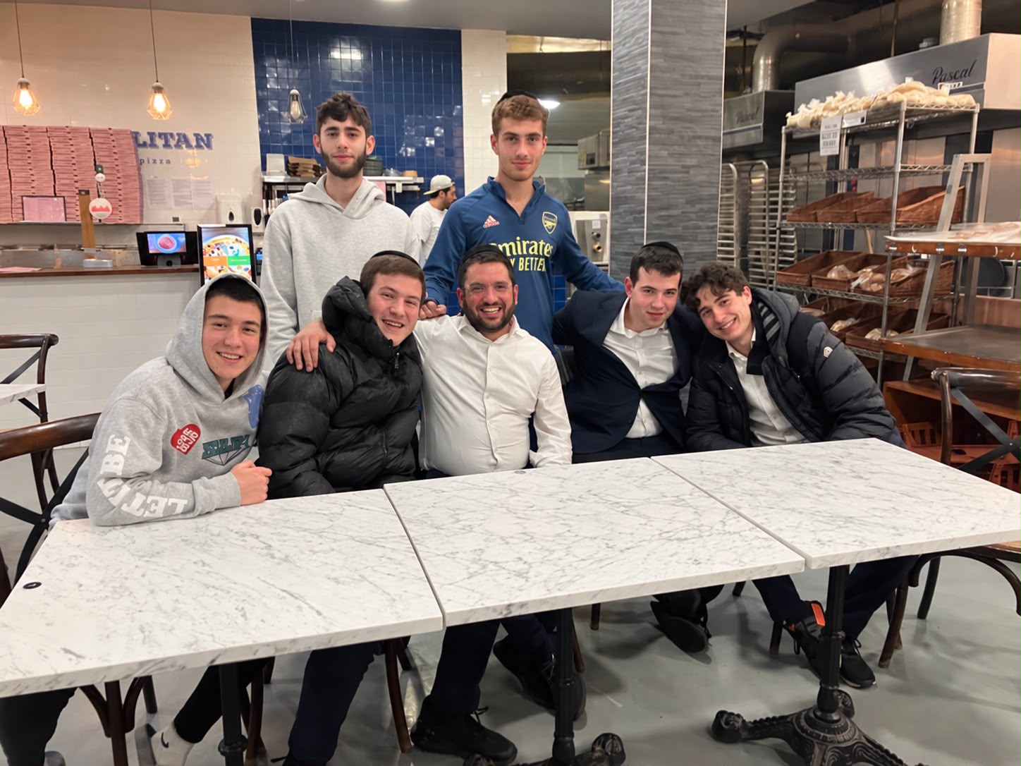 Rabbi Aidyn with students gathered around a table